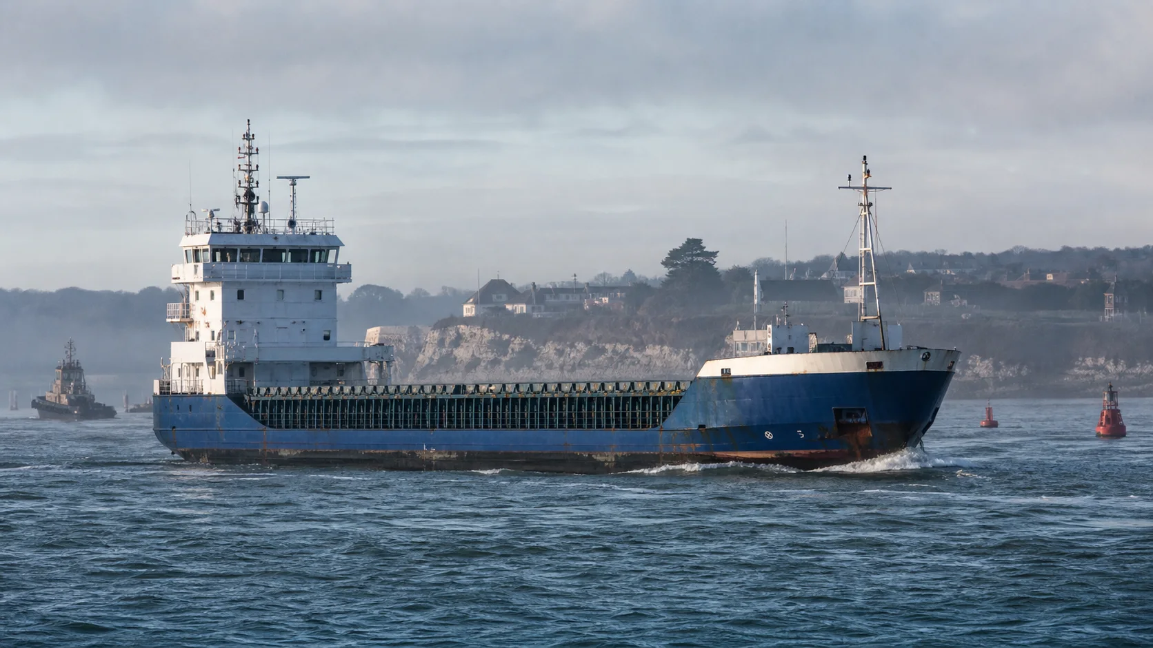 Working commercial freighter underway through a coastal shipping channel