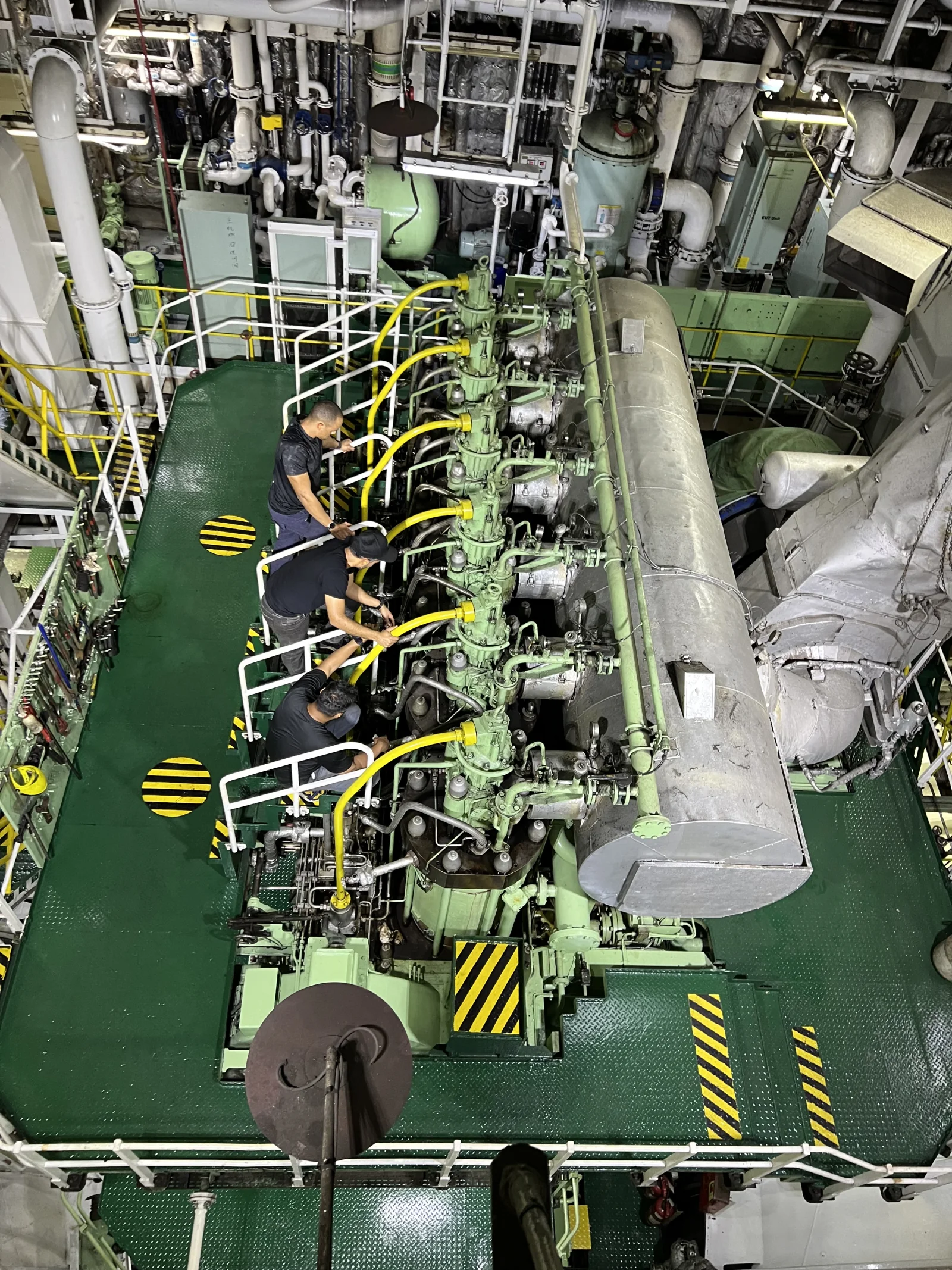 Newlight engineers inspecting machinery inside a ship engine room